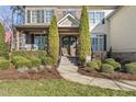 Inviting front entrance with double doors, stone accents, and well-manicured landscaping at 7112 Hasentree Way, Wake Forest, NC 27587