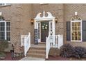 Elegant front door entrance with white railings and a wreath at 7828 Percussion Dr, Apex, NC 27539