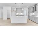 Contemporary kitchen with white island, modern appliances, and pendant lighting at 804 Heathered Farm Way, Apex, NC 27523