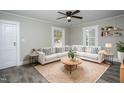 Cozy living room featuring a ceiling fan, rug, white sofa, and natural light from two windows at 925 Redgate Ave, Rocky Mount, NC 27801