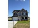Two-story house with gray siding, a driveway, and a landscaped yard at 16 Shiloh Dr, Lillington, NC 27546