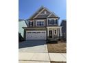 Charming new construction home with a stone facade, two-car garage, and classic black shutters at 2405 Englemann Dr # 121, Apex, NC 27502