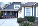 Close-up of a blue home with a cozy front porch and well-maintained landscaping at 241 Serenity Hill Cir, Chapel Hill, NC 27516