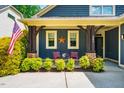 The welcoming front porch features stylish design with a unique star decoration, colorful chairs, and manicured bushes at 241 Serenity Hill Cir, Chapel Hill, NC 27516