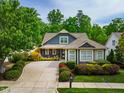Charming home with a well-manicured front yard, a concrete driveway and mature trees creating a beautiful curb appeal at 241 Serenity Hill Cir, Chapel Hill, NC 27516