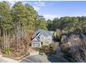 Two-story house nestled in a wooded lot, featuring a gray exterior and a paved driveway at 2500 Shadow Hills Ct Ct, Raleigh, NC 27612