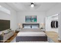 Staged bedroom with a walk-in closet, large bed, and views of the surrounding area at 615 Daniels St # 316, Raleigh, NC 27605