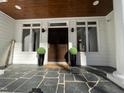 Stylish front door with black slate tile and decorative plants on the entryway porch at 811 Oxbow Crossing Rd, Chapel Hill, NC 27516