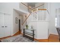 Bright foyer featuring hardwood floors, elegant staircase, and a stylish glass console table at 105 Wohler Ct, Cary, NC 27513