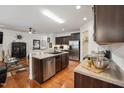 Modern kitchen features stainless steel appliances, dark wood cabinets, and a central island with sink at 320 Westgrove Ct, Durham, NC 27703