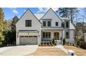 Beautiful white brick home featuring a three-car garage and meticulously landscaped front yard at 3304 Cheswick Dr, Raleigh, NC 27609