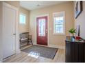 Light-filled entryway with a bench, dark console table, and red door at 512 Beacon Ridge Blvd, Chapel Hill, NC 27516