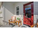 Inviting front porch with wooden chairs and a red front door at 512 Beacon Ridge Blvd, Chapel Hill, NC 27516