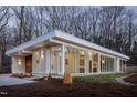 Stunning exterior view of modern home featuring clean lines, large windows, and wood accents surrounded by trees at 6358 Pathway Ct Ct, Chapel Hill, NC 27516