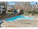 Community swimming pool with brick patio and surrounding trees at 720 Bishops Park Dr # 305, Raleigh, NC 27605