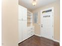 Bright entryway with hardwood floors, built-in storage cabinets, and a windowed front door at 7205 Ladbrooke St, Raleigh, NC 27617