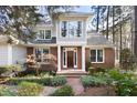 Inviting brick and siding home boasts a beautiful yard, large windows and a welcoming dark wood door at 76527 Rice, Chapel Hill, NC 27517