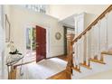 Inviting foyer featuring hardwood floors, staircase, and an open red front door allowing natural light at 76527 Rice, Chapel Hill, NC 27517