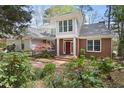 Charming two-story brick home featuring an inviting entrance and lush, mature landscaping at 76527 Rice, Chapel Hill, NC 27517