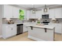 Modern kitchen with white cabinets, quartz countertops, and stainless steel appliances at 802 Brookfield Dr, Gibsonville, NC 27249