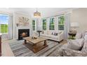 Cozy living room with a fireplace, large windows, and comfortable seating at 802 Brookfield Dr, Gibsonville, NC 27249