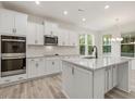 Spacious kitchen with white cabinets, large island, and stainless steel appliances at 806 Brookfield Dr, Gibsonville, NC 27249