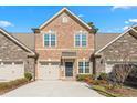 Two-story townhome with brick and stone exterior, two-car garage, and curb appeal at 1099 Talisker Way, Burlington, NC 27215