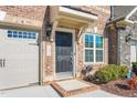 Inviting front entrance with dark-stained door and brick facade at 1099 Talisker Way, Burlington, NC 27215