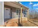 Brick steps leading to a covered front porch with gray siding at 1523 Alta Vista Ln, Graham, NC 27253