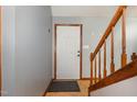Inviting entryway with wood-trimmed staircase and a view of the front door and adjacent walls at 211 Dwelling Pl, Knightdale, NC 27545