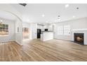 Open living room with fireplace, kitchen island, and wood-look floors at 2730 Erinridge Rd, Raleigh, NC 27610