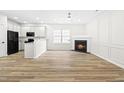 Living room with fireplace, kitchen island, and wood-look floors at 2730 Erinridge Rd, Raleigh, NC 27610