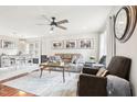 Open living room with a cozy gray sofa, wood floors, area rug, and modern ceiling fan at 501 Pearson Dr, Durham, NC 27713
