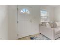 Bright entryway with white door, tile floor, and a comfy couch at 830 E Lenoir St, Raleigh, NC 27601
