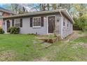 Gray duplex unit with a dark door, stone steps, and grassy yard at 830 E Lenoir St, Raleigh, NC 27601