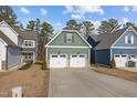 Two-story house with green siding, two-car garage, and a landscaped yard at 104 Spruce Hollow Cir, Spring Lake, NC 28390