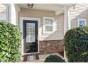 Black front door with sidelights and stone base at 11215 Lofty Heights Pl, Raleigh, NC 27614