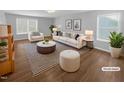 Virtually staged living room featuring a comfortable sofa and armchairs, a coffee table, and a stylish rug at 1611 Copper Cir, Mebane, NC 27302