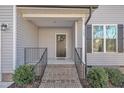 Brick steps leading to a dark gray front door with black shutters at 167 Black Cloud Dr, Louisburg, NC 27549
