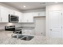 Modern kitchen with white cabinets, granite counters, and stainless steel appliances at 18 Virgo Dr, Angier, NC 27501