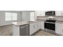 Kitchen with granite island, stainless steel appliances, and hardwood floors at 18 Virgo Dr, Angier, NC 27501