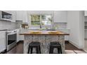 Bright kitchen with white cabinets, a herringbone island, and stainless steel appliances at 205 Spring St, Louisburg, NC 27549