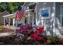Charming home exterior with an American flag and colorful azaleas along walkway at 223 N Main St, Wendell, NC 27591