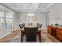 Formal dining room with coffered ceiling, granite table, and hardwood floors at 241 Fair Oaks Ct, Mebane, NC 27302