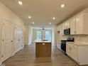 Bright kitchen with modern appliances, an island, and white cabinets offering a clean, contemporary look at 494 Traditions Grande Blvd # 25, Wake Forest, NC 27587