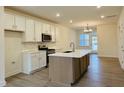 Well-lit kitchen featuring stainless steel appliances, a kitchen island, and stylish backsplash at 494 Traditions Grande Blvd # 25, Wake Forest, NC 27587