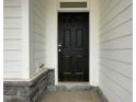 Classic black front door with digital lock, enhanced by stone accents and white siding at 496 Traditions Grande Blvd # 24, Wake Forest, NC 27587