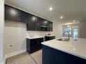 Modern kitchen featuring sleek black cabinets, stainless steel appliances, and a spacious island at 496 Traditions Grande Blvd # 24, Wake Forest, NC 27587