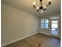 Bright dining area featuring a modern chandelier and convenient access to the outdoor patio at 498 Traditions Grande Blvd # 23, Wake Forest, NC 27587