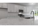 Modern kitchen with stainless steel appliances, granite counters, and white subway tile backsplash at 500 Traditions Grande Blvd # 22, Wake Forest, NC 27587